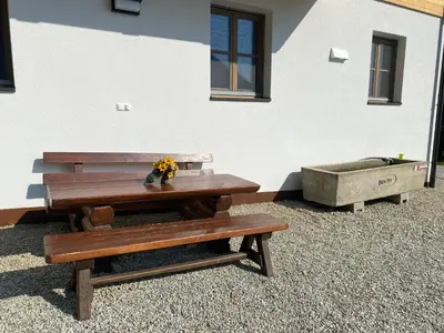 a picnic table and a dog bed next to a building at Kröllhof in Vallarga