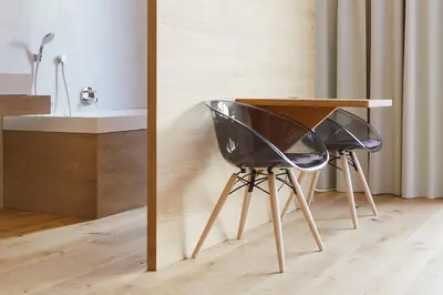 a desk with two black chairs next to a table at Steindl's Boutique Hotel in Vipiteno