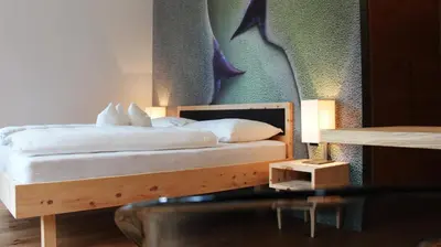 a bed with white sheets and pillows in a room at Steindl's Boutique Hotel in Vipiteno