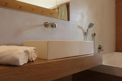 a bathroom with a sink and towels on a counter at Steindl's Boutique Hotel in Vipiteno