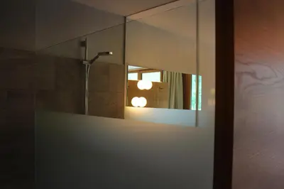 a bathroom with a mirror and a shower at Steindl's Boutique Hotel in Vipiteno