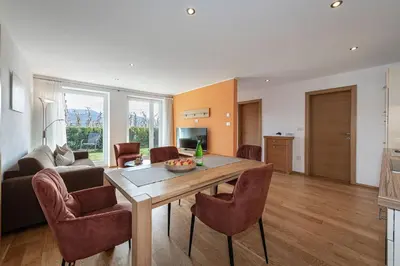 a living room with a wooden table and chairs at Tirolerhof - panoramic apartments in Naz-Sciaves