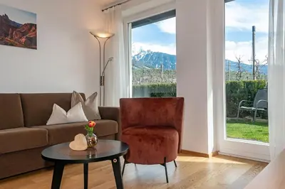 a living room with a couch and a table and a window at Tirolerhof - panoramic apartments in Naz-Sciaves