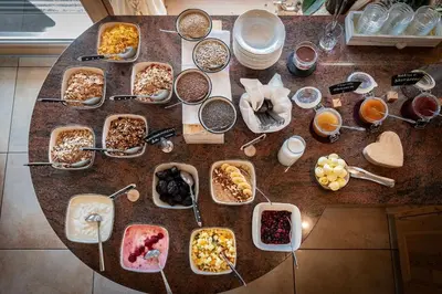 a table topped with bowls of breakfast foods and drinks at Tirolerhof - panoramic apartments in Naz-Sciaves
