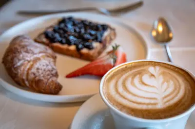 a cup of coffee next to a plate of food at Tirolerhof - panoramic apartments in Naz-Sciaves