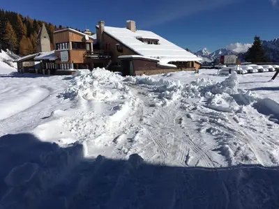 a pile of snow in front of a house at Casa Neve e Sole - presso Sussy Residence in Falcade
