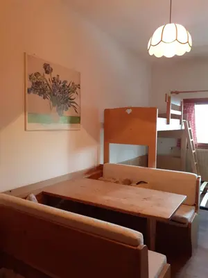 a living room with a wooden table and a couch at Casa Neve e Sole - presso Sussy Residence in Falcade