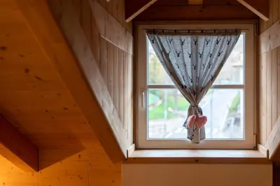 a window with a curtain in a room at Mansarda Cermis in Cavalese