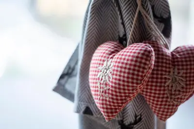 two red hearts are hanging on a wall at Mansarda Cermis in Cavalese