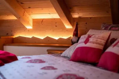 a bedroom with a bed and a wooden ceiling at Mansarda Cermis in Cavalese