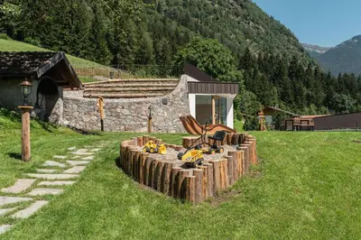 a pile of logs in front of a stone building at Innermoser Bauernhof - Chalets in Molini di Tures
