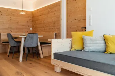 a bedroom with a bed and a desk with chairs at Innermoser Bauernhof - Chalets in Molini di Tures