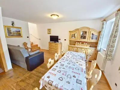 a living room with a table and a couch at Villetta Clara by AMA Val di Fassa in Vigo di Fassa