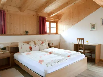 a bedroom with a bed and a desk in a attic at Chalet in Funes Valley with Dolomites Views in Funes