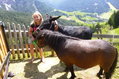 a little girl and a dog standing on a horse at Chalet in Funes Valley with Dolomites Views in Funes