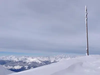 a snow covered mountain with a pole on top of it at Chalet in Funes Valley with Dolomites Views in Funes