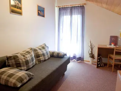 a living room with a couch and a window at Chalet in Funes Valley with Dolomites Views in Funes