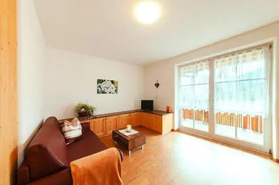 a living room with a couch and a large window at Apartment in Brixen with Pool & Dolomites Views in Naz-Sciaves