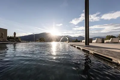 a pool of water with the sun in the background at Santre dolomythic home in Bressanone