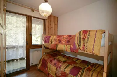 two bunk beds in a room with a window at Appartamenti Cercenà in Canazei