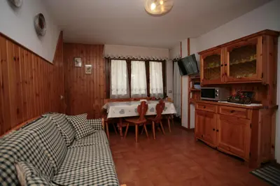a kitchen with a table and chairs in a room at Appartamenti Cercenà in Canazei