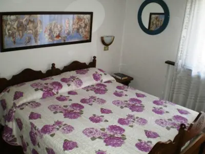 a bedroom with a bed with purple flowers on it at Appartamenti Cercenà in Canazei