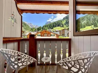 a balcony with two chairs and a window with a view at B&B Cèsa Planber Mountain View SKI-IN SKI-OUT in Canazei