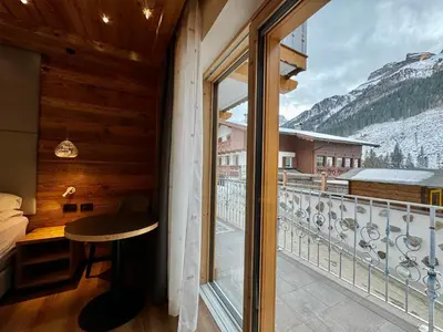 a room with a balcony with a view of a mountain at B&B Cèsa Planber Mountain View SKI-IN SKI-OUT in Canazei