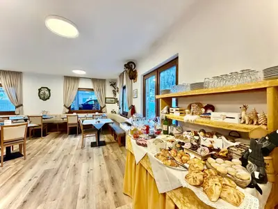 a room with tables filled with bread and pastries at B&B Cèsa Planber Mountain View SKI-IN SKI-OUT in Canazei