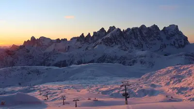 a snow covered mountain with a ski lift in the foreground at Chalet Scoiattolo Residence Sussy in Falcade