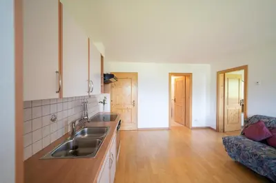 a kitchen with a sink and a living room at Fortschöllhof in Castelrotto