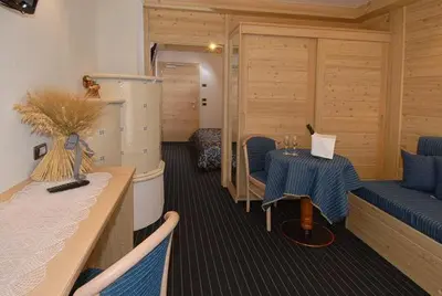 a room with a table and chairs in a room at Hotel Flora Alpina in Campitello di Fassa