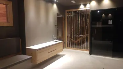 a bathroom with a sink and a glass shower at Hotel Flora Alpina in Campitello di Fassa