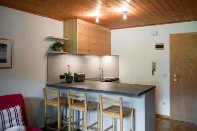 a kitchen with a counter and stools in a room at Residence Veider in Rasùn di Sotto