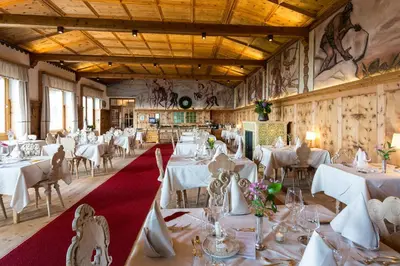 a dining room with white tables and chairs at Berghütte Sommerstall in Redagno