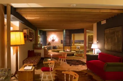 a living room with a red couch and a fireplace at Berghütte Sommerstall in Redagno