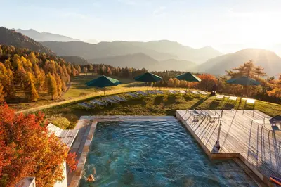 an overhead view of a swimming pool with umbrellas at Der Zirmerhof in Redagno
