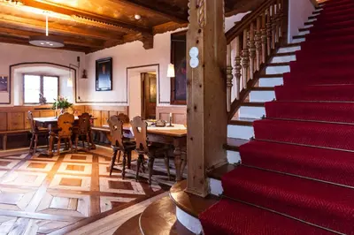 a room with a red staircase and a table and chairs at Der Zirmerhof in Redagno