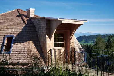 a house with a roof with a balcony at Der Zirmerhof in Redagno