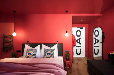 a bedroom with red walls and a bed with pillows at Sport Hotel Passo Carezza in Vigo di Fassa