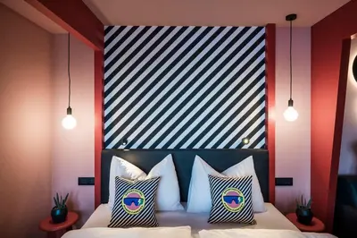 a bedroom with a bed with a black and white headboard at Sport Hotel Passo Carezza in Vigo di Fassa