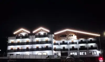 a large building with lights on it at night at Hotel Pizboè in Mazzin