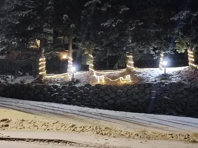 a night view of a stone wall with lights at Hotel Pizboè in Mazzin