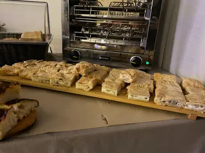a bunch of sandwiches on a cutting board next to a toaster oven at Hotel Pizboè in Mazzin