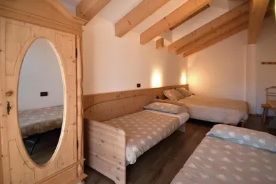 a bedroom with two beds and a mirror at Residence Garni Manuela in Cavalese