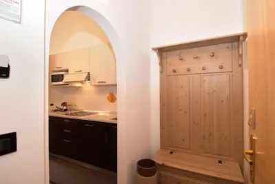 a kitchen with a large wooden door and a sink at Residence Garni Manuela in Cavalese