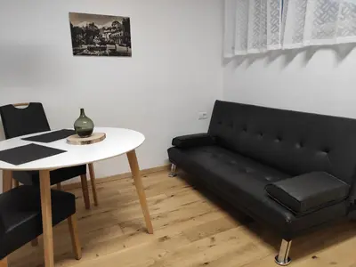 a living room with a black couch and a table at Apartment Hagen in Merano