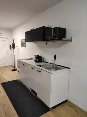 a white kitchen with a sink and a counter top at Apartment Hagen in Merano