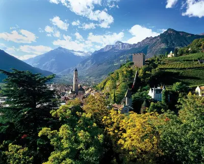 a town on a hill with mountains in the background at Alpina Residence in Naturno