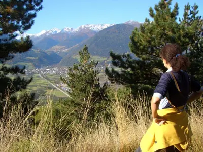 a woman standing on a hill looking at the mountains at Alpina Residence in Naturno